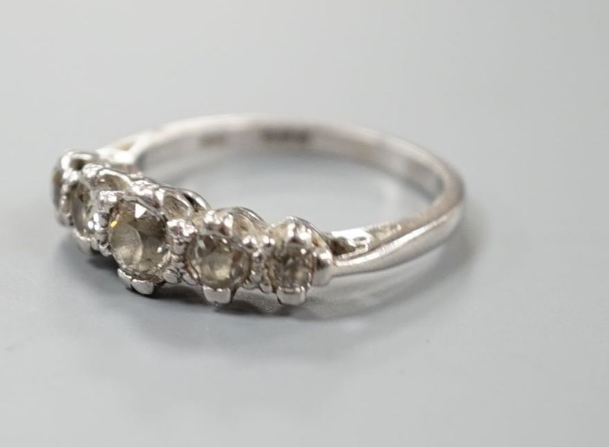 A modern platinum and graduated five stone diamond set half hoop ring, size P/Q, gross weight 6 grams.